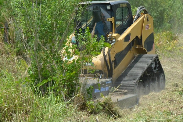 Extreme duty bush hog attachmen on a compact track loader machine clearing thick brush 